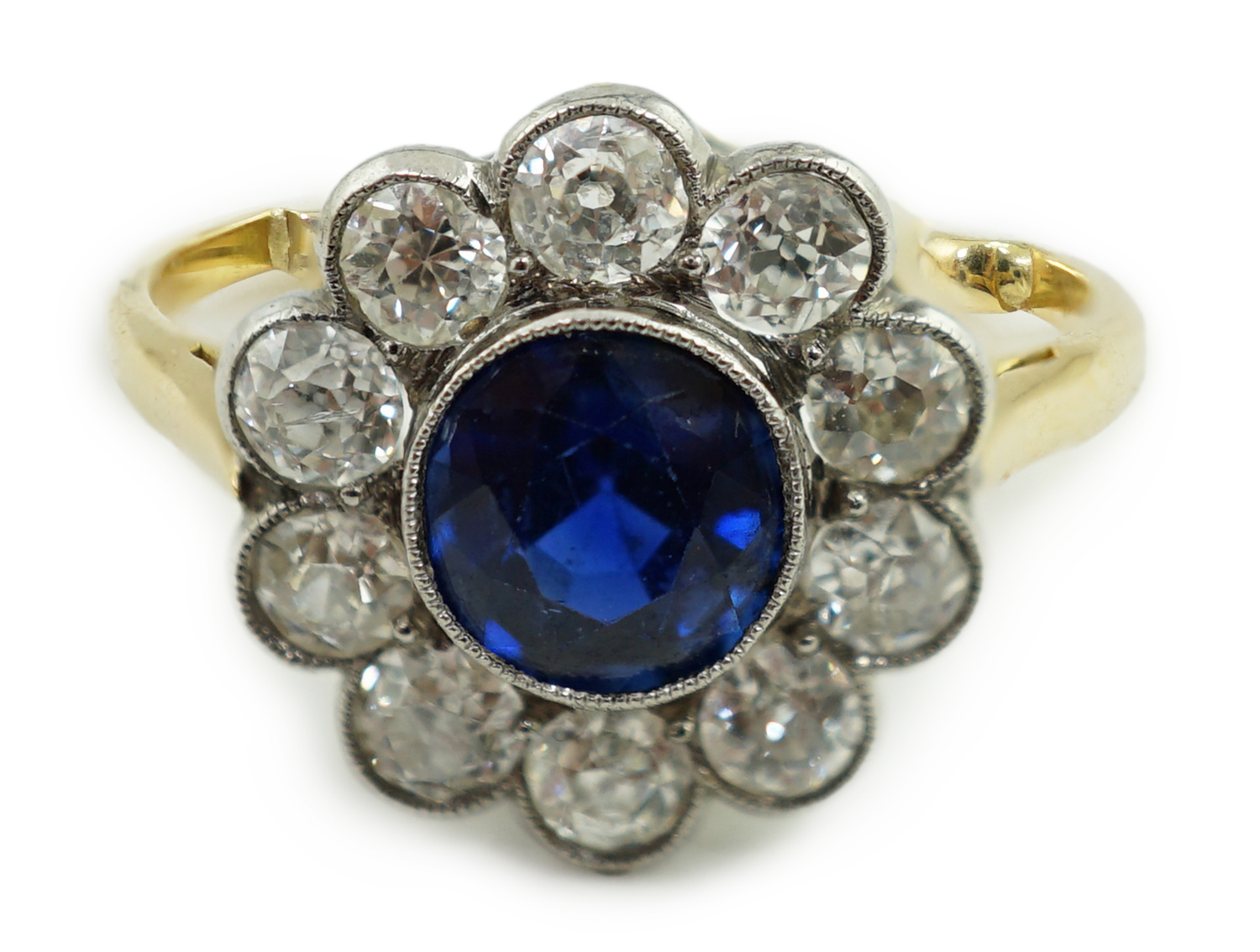 A mid 20th century gold, sapphire and millegrain set diamond flower head cluster ring